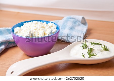cottage cheese in a bowl next to a large dollop of sour cream