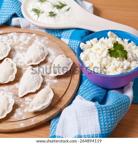 raw dumplings with cottage cheese on a cutting board