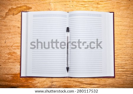Open Address Book with a ballpoint pen on the wooden background