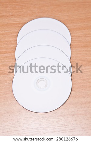 White optical disks on the wooden background