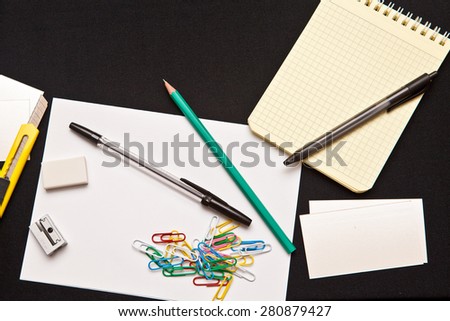 office supplies scattered on a dark fabric background
