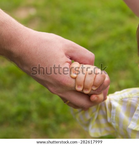 Father and son holding hands, close-up