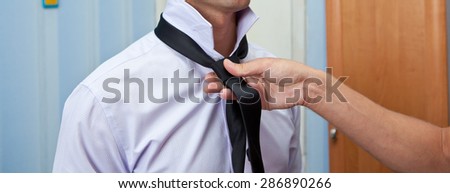 man tie a tie, close-up