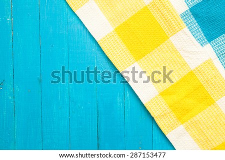 yellow and blue dotted towels in the cage on a blue wooden background