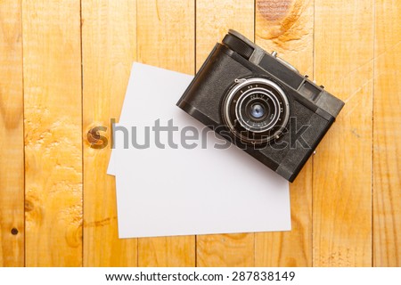 old film camera with a photo on a wooden background