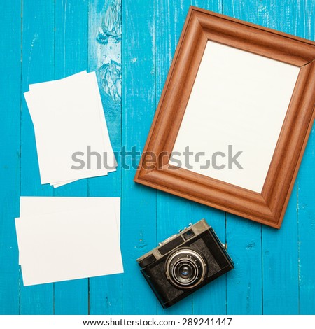 retro camera, photo frame and photo on a blue wooden background