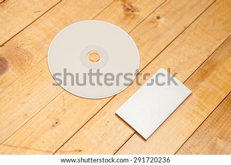 DVD disk and business card on a wooden background