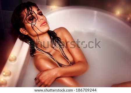 beautiful young woman brunette in the bath with milk