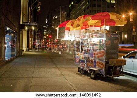 NYC - APRIL 29: A hot dog stand vendor stays open late into the night in New York City on April 29, 2013 in order to sell a few more hot dogs to late night passerbys.