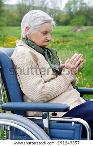 Handicapped elderly woman sitting in a wheelchair outdoor