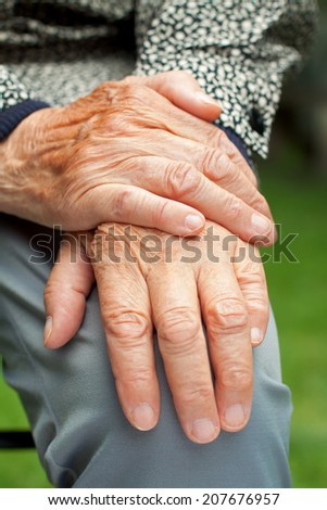 Elderly woman touch her wrinkled hand