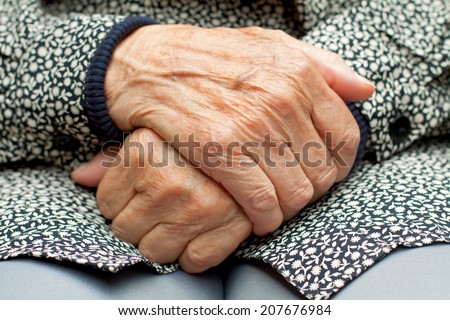 Elderly woman touch her wrinkled hand