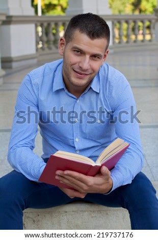 Picture of a handsome man reading an interesting book