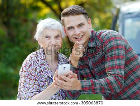 Grandmother and grandson using a white smartphone