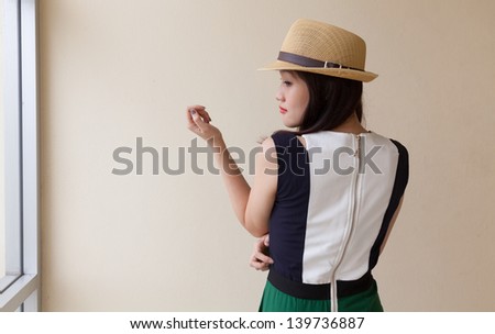 Portrait of young asian girl in fashion green jumpsuit wearing hat