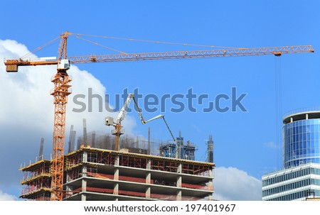 Concrete pump on high rise building under construction with crane.