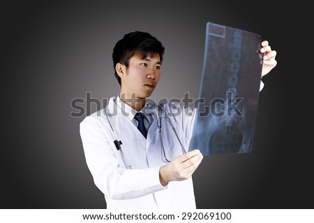 close up of male doctor holding x-ray or roentgen image on black background