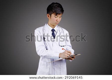 Portrait of southeast Asian male medical doctor showing and pointing to a blank empty clip file with space, Young man model.