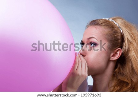 young girl inflates the balloon funny
