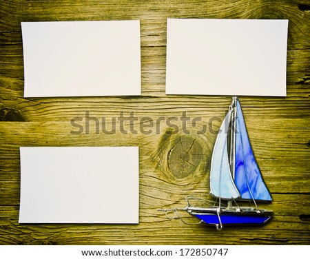 Vintage boat on old wood surface and blank piece of paper