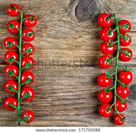 Red cherry tomatoes lying on a textured rustic wooden