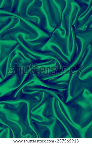 abstract background luxury cloth or liquid wave or wavy folds of grunge green silk texture satin velvet material or luxurious