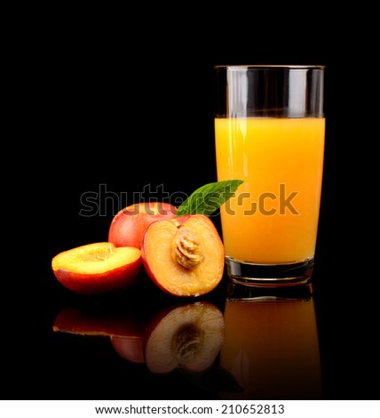 Studio shot of sliced orange nectarines with leaf and nectarine juice isolated on a black background