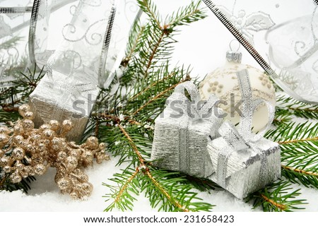 Decoration of silver christmas gifts, silver ribbon on snow christmas tree branch on white