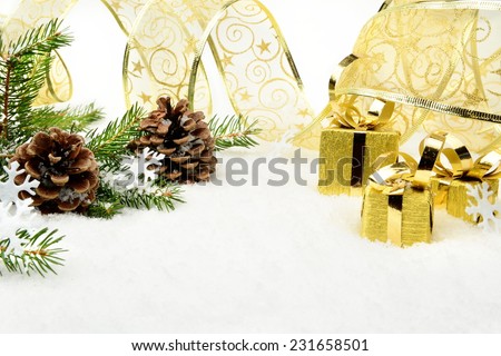 Decoration of gold christmas gifts, gold ribbon on snow christmas tree branch on white