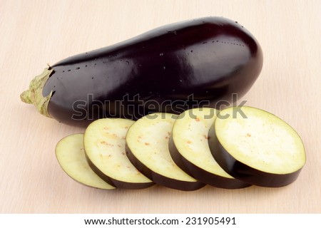Close-up view of wet eggplant,aubergine fruit with drop water on bright wooden table