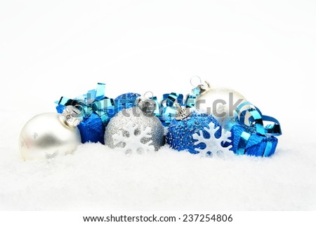Decoration of blue,silver christmas baubles and gifts on snow white background