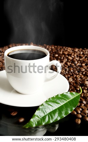 Cup of coffee,mist,coffee leaf and coffee beans isolated on black