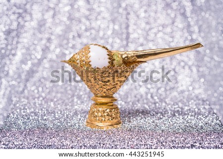 Conch shell on golden tray for blessed water in Thai wedding ceremony on bokeh background