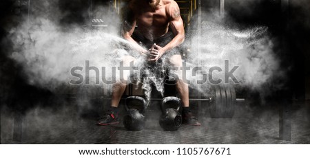 Muscular man clapping hands and preparing for workout at a gym
