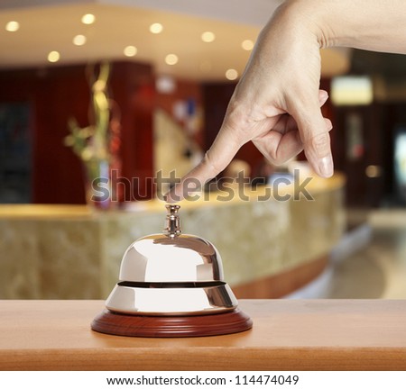 Hand of a woman using a hotel bell
