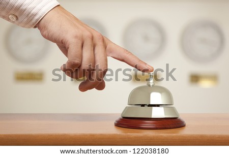 Hand of a businessman using a hotel bell