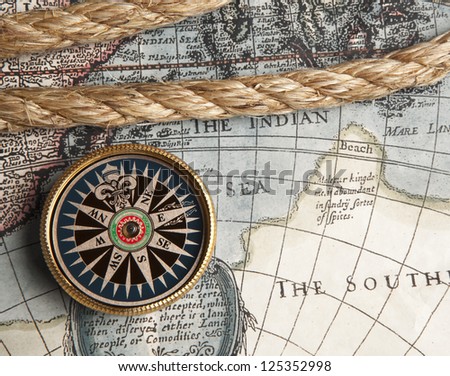 Old compass and rope on vintage map