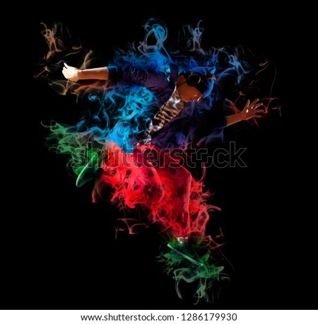 Young man break dancing on dark smoke background