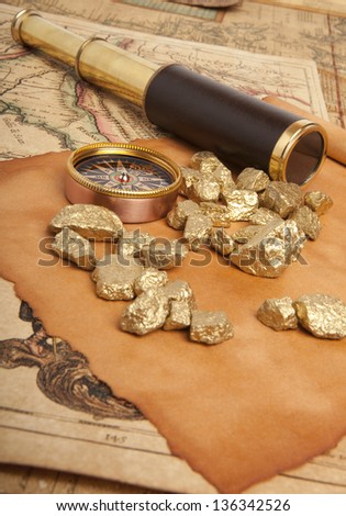 Gold nuggets and vintage brass telescope on antique map