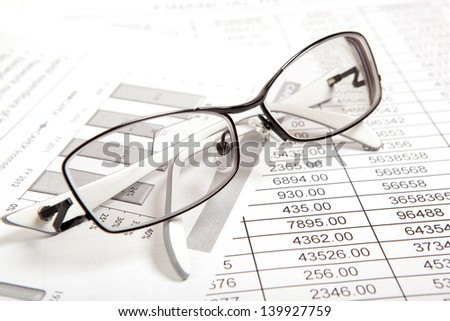 Glasses on paper table with finance report