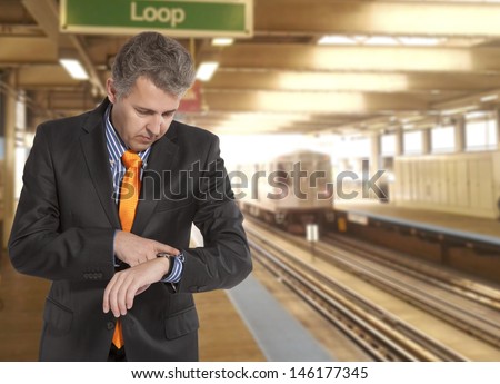 Train delay. Businessman looking at his watch