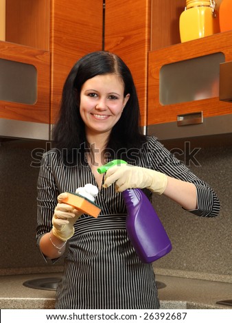 The girl on kitchen sprayed soap on sponge