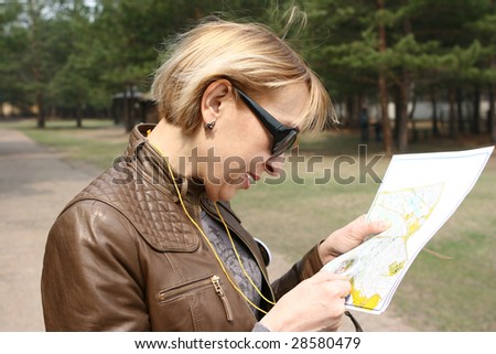 The woman with a compass studies a map sports orientation