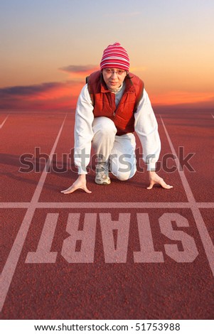 Athletic woman in start position on track