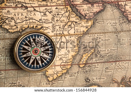 Old compass on vintage retro map 1687
