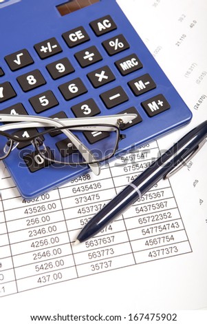 Glasses and calculator on paper table with finance report