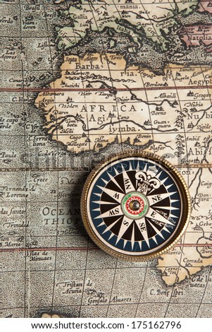 Old compass on vintage retro map 1687