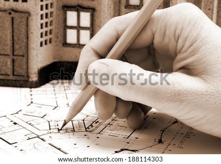 Female architect hand and house model