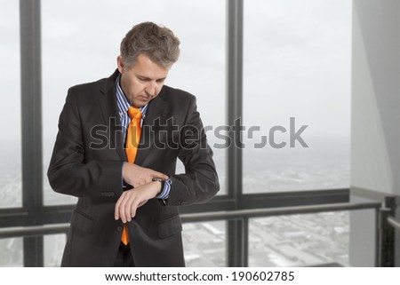Checking the time. Worried adult businessman