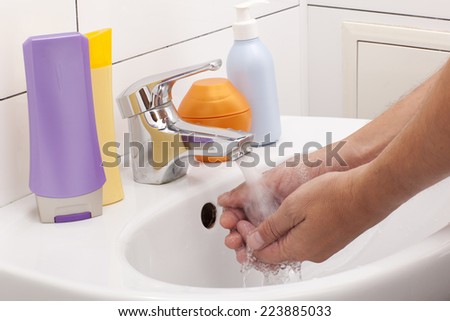 Washing of hands with soap in bathroom close up